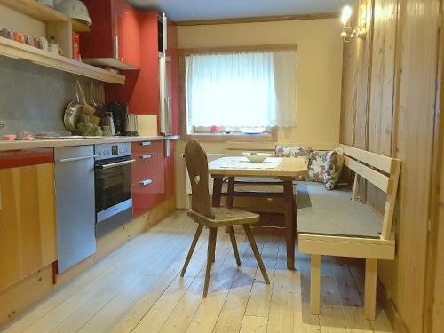 cocina con mesa pequeña, mesa y sillas en Ferienwohnung Senftahaus, en Innervillgraten