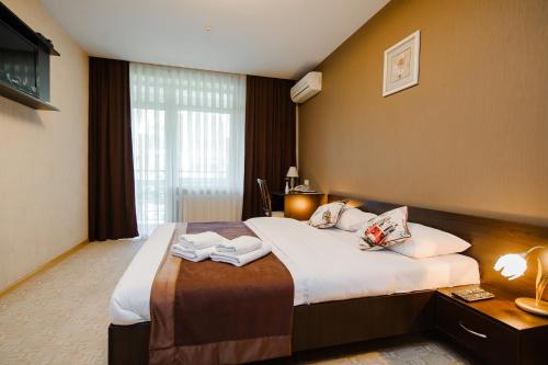 a hotel room with a large bed with towels on it at TipTop Hotel CITY CENTER in Chişinău
