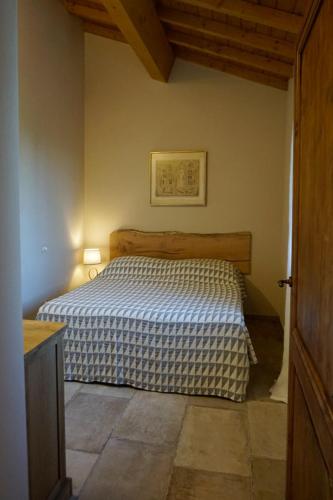 a bedroom with a bed with a blue and white blanket at Agriturismo Cheloni in Guasticce
