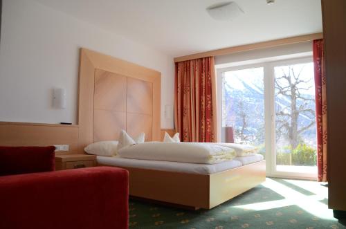 ein Schlafzimmer mit einem Bett und einem großen Fenster in der Unterkunft Villa Buchenhain in Ehrwald