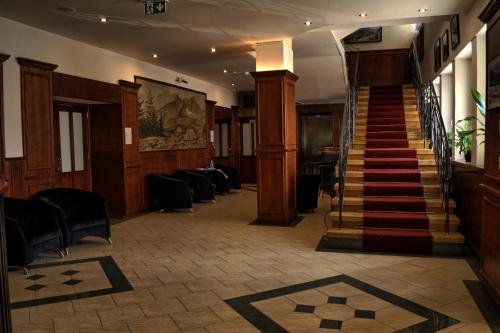 a lobby with stairs and chairs and a stair case at Ośrodek Wypoczynkowy Start in Zakopane