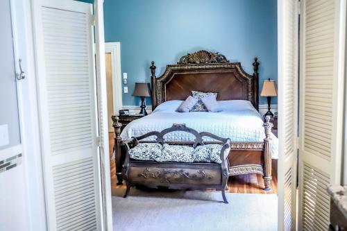 a bedroom with a large bed with blue walls at Early Inn at the Grove in Rocky Mount
