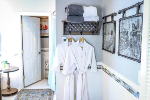 um quarto com roupas brancas penduradas numa parede em Early Inn at the Grove em Rocky Mount