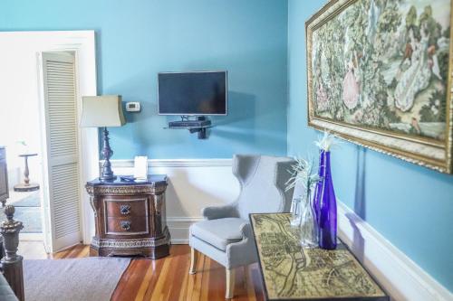 a blue room with a table and a tv on a wall at Early Inn at the Grove in Rocky Mount