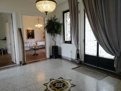 a living room with a table and a chandelier at VILLA HENRI in Flavy-le-Martel