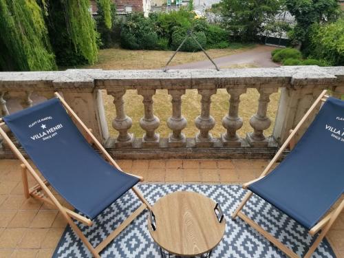 two lawn chairs sitting on a balcony at VILLA HENRI in Flavy-le-Martel
