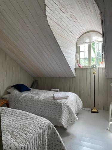 1 dormitorio con 2 camas y un ático en Arphus Lodge, en Eskilstuna
