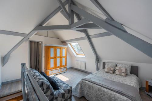 a attic bedroom with a bed and a chair at El arco iris entre port et plage in Dieppe