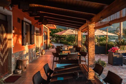 an outdoor patio with tables and chairs and umbrellas at B&B La Mortella in Albanella