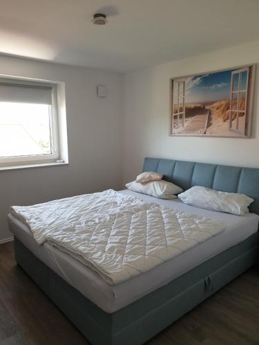 a bed in a bedroom with a blue couch at Naturpur die Wellnessoase in Leezen