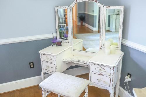 a white dressing table with a mirror and a stool at Early Inn at the Grove in Rocky Mount