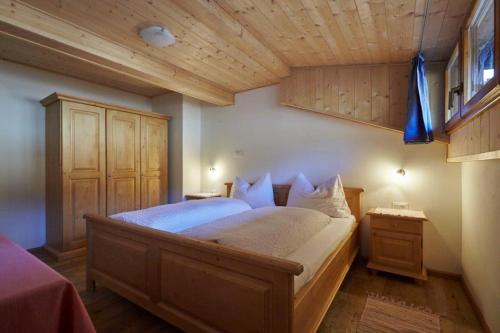 a bedroom with a large bed and a wooden ceiling at THOMASERHOF in Redagno