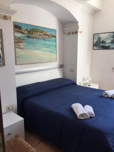 a bedroom with a blue bed with two towels on it at BELVEDERE in La Maddalena