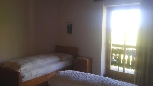 a bedroom with two twin beds and a window at THOMASERHOF in Redagno