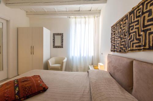 ein Schlafzimmer mit einem Bett und einem Stuhl darin in der Unterkunft Corte Quaranta in Verona