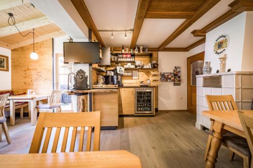 a kitchen and dining room with wooden tables and chairs at Pension Gimpl, Chiemgaukarte neu in Siegsdorf