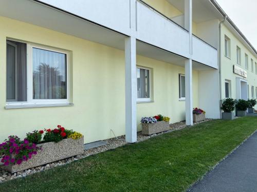 a building with flower boxes on the side of it at Pension Schmidt in Podersdorf am See