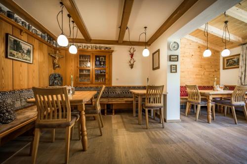 a dining room with wooden tables and chairs at Pension Gimpl, Chiemgaukarte neu in Siegsdorf
