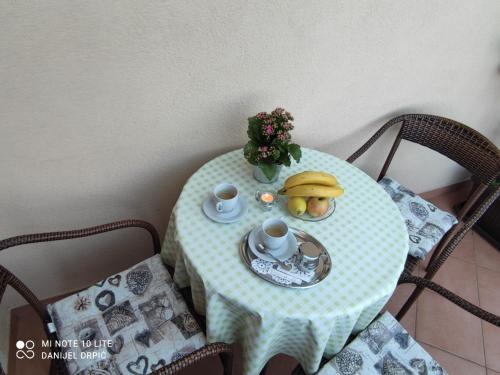 a table with a plate of fruit and a banana on it at Apartments Drpic in Gabonjin