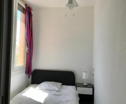 ポール・ラ・ヌーヴェルにあるCAPRI 2の窓とベッドサイドシックスが備わるドミトリールームのベッド1台分です。