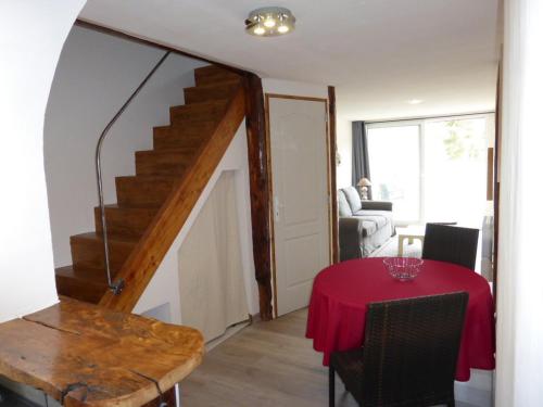 une salle à manger avec une table et un escalier dans l'établissement l'Aviateur,proche aérodrome, meublé 4pers, à Saint-Pons