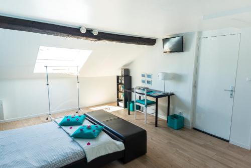une chambre avec un lit et un bureau dans une pièce dans l'établissement Escale à Épernay, à Épernay