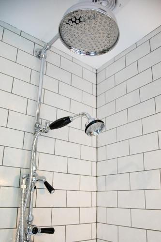 a shower in a bathroom with white tiles at Beautiful Luxury Property in the Surrey Hills in Cranleigh