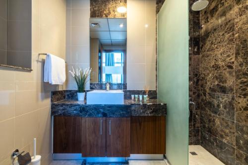 a bathroom with a sink and a shower at The Smart Concierge - Bay Central in Dubai