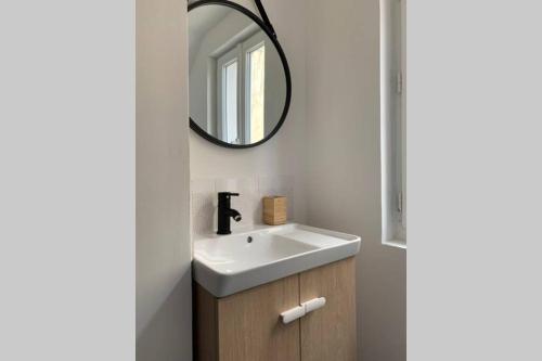 ein Bad mit einem Waschbecken und einem Spiegel in der Unterkunft chez LULU appartement neuf au coeur de cozzano in Cozzano