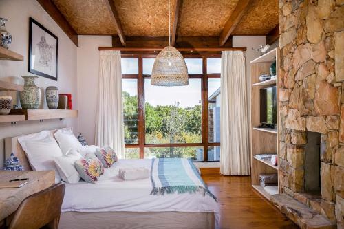 a bedroom with a bed and a large window at Kinghorns Gardens in Cape Town