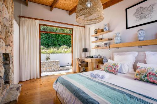 a bedroom with a bed and a large window at Kinghorns Gardens in Cape Town