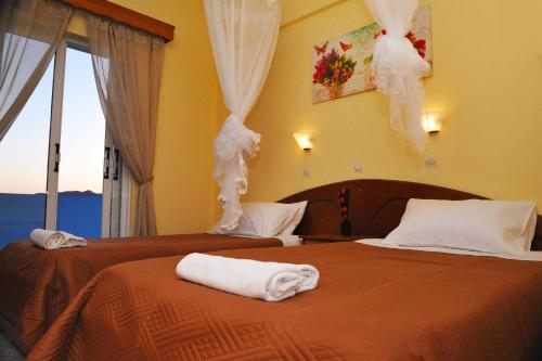 Dos camas en una habitación de hotel con toallas. en theophilos blue cozy apartments, en Agios Georgios Pagon