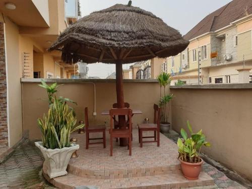 une terrasse avec une table, des chaises et un parasol dans l'établissement executive 4bedrooms house in Lagos Nigeria, à Lekki