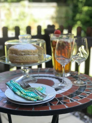 a table with a cake and two glasses of wine at Brampton Luxury Annexe Apartment in Huntingdon
