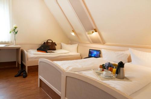 a room with two beds and a laptop on a table at Häuser der Villa Italia in Marktheidenfeld