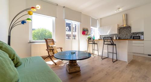 a living room with a table and a kitchen at Lyves Two in Liège
