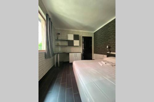 1 dormitorio con cama y pared de ladrillo en Cute Little House with a White Picket Fence en Burgas