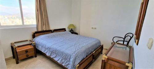 een kleine slaapkamer met een bed en een raam bij Torre Levante/32 in Benidorm