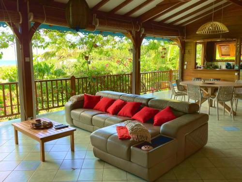 a living room with a couch and a table at Villa Nature caraïbe lodge, vue mer, piscine privée in Deshaies