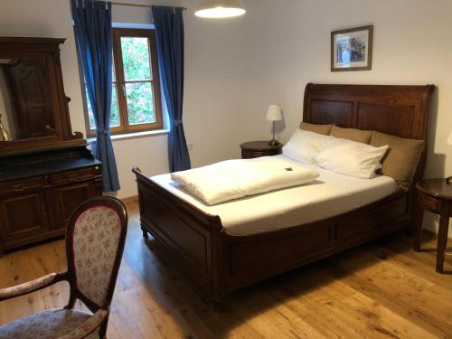 a bedroom with a bed and a chair and a window at Gasthof Zur Post in Wolnzach