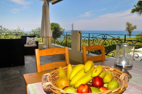 a basket of fruit on a table on a balcony at Holiday House Angelos C on Agios Gordios Beach in Agios Gordios