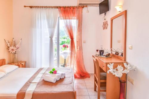 a bedroom with a bed and a desk and a window at House Ilias in Sarti