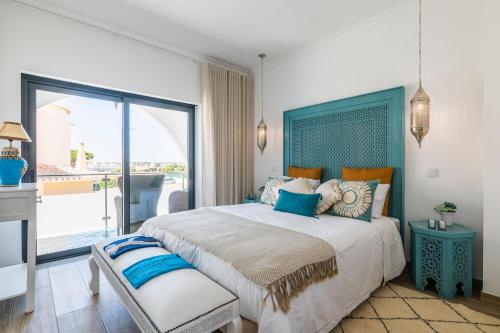 ein Schlafzimmer mit einem großen Bett und einem Balkon in der Unterkunft Riad Matias Galé - Luxury Villa with private pool, AC, free wifi, 5 min from the beach in Guia