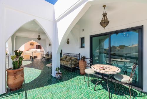 a room with a patio with a table and chairs at Riad Matias Galé - Luxury Villa with private pool, AC, free wifi, 5 min from the beach in Guia