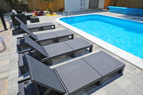 a group of chairs and a swimming pool at Apartment 877-2 in Bibinje