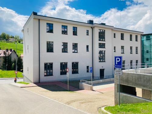a white building with a parking sign in front of it at Residence Kotel in Rokytnice nad Jizerou