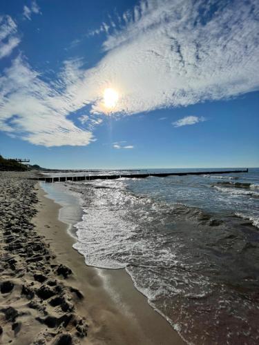 - une plage avec l'océan et une jetée dans l'établissement Pokoje Gościnne i Apartamenty Ula, à Ustronie Morskie