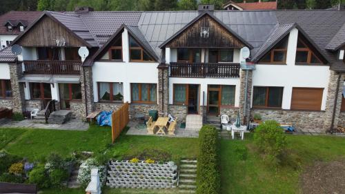 een groot huis met een veranda en een tuin bij Apartmány Kubova Huť in Kubova Huť