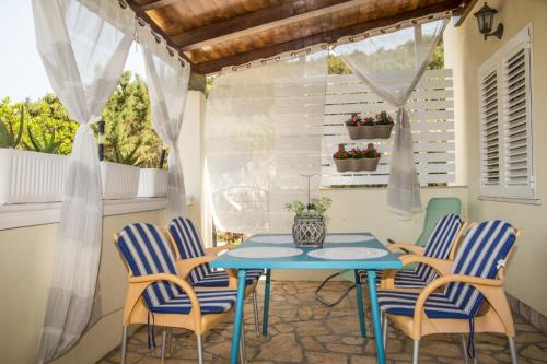 eine Terrasse mit einem blauen Tisch und Stühlen in der Unterkunft Apartments Petranić in Tisno
