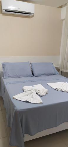 - un lit bleu avec 2 serviettes blanches dans l'établissement Sol e Mar Solar do Atlântico, à João Pessoa